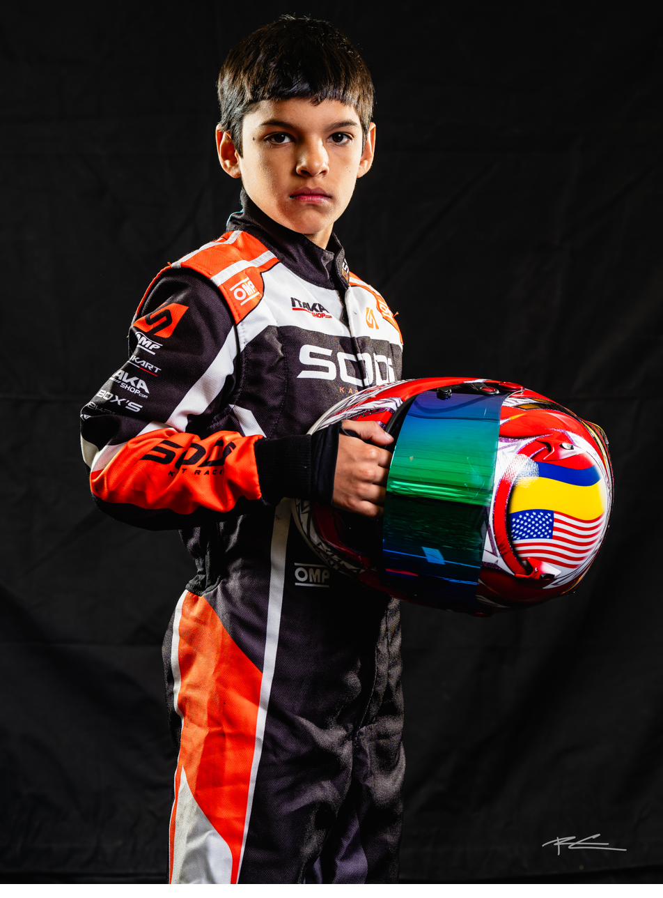Studio portrait of Tommy Pretelt holding his racing helmet